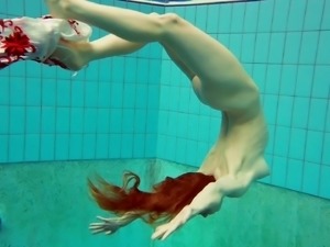 Redhead European model diving with attire underwater