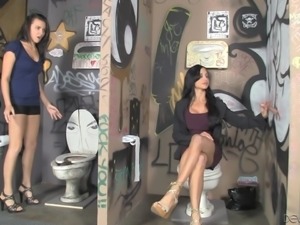 Two gorgeous brunettes enjoy sucking a dick through a gloryhole