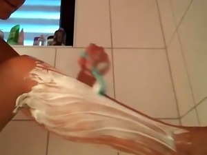 Amateur wife shaving her legs and her pussy in the shower